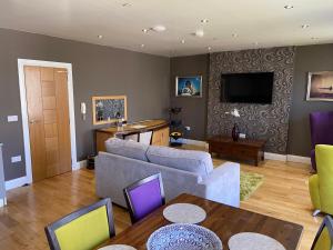 a living room with a couch and a tv at Halvard Apartments at Castletown in Castletown