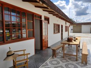 un patio de una casa con mesa y bancos en LETICIAS GUEST HOUSE en Leticia