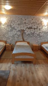 1 dormitorio con 1 cama con un árbol en la pared en uKozaków en Zubrzyca Dolna
