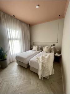 Habitación de hotel con 2 camas y ventana en 402 - GoodHouse Hillel St en Jerusalén