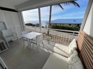 a balcony with a white couch and a table and chairs at Appartement Luxe Ocean View 9403 in Cul de Sac