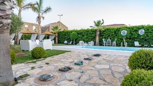 einen Hinterhof mit einem Pool und einem Resort in der Unterkunft Villa Caleo in Gioia Tauro