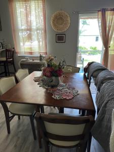 una mesa de comedor con un jarrón de flores. en Quite room in a family home, en Lehigh Acres