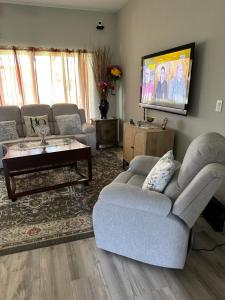 sala de estar con sofá y TV en Quite room in a family home, en Lehigh Acres