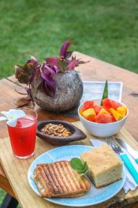 un tavolo con un piatto di cibo e un cesto di frutta di Back to the Beach Hostel - Pipa a Pipa