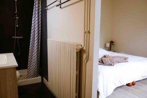 1 dormitorio con radiador junto a la cama en Le château rouge, en Écommoy