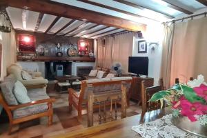 EscalonaにあるCasa Rural Emiliaのソファとテーブルとテレビのあるリビングルーム