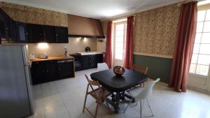 eine Küche mit einem Tisch und Stühlen in der Unterkunft Maison de caractère / Petit Versailles Normand in Valognes