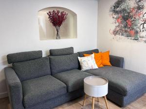 sala de estar con sofá gris y almohadas de color naranja en LX History Hotel en Lisboa