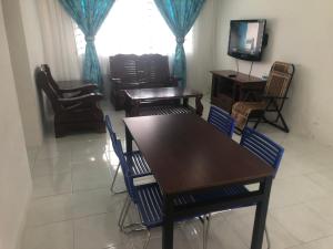 a dining room with tables and chairs and a television at AGMA Homestay in Kuantan