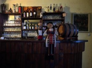 a doll is standing at a bar with a barrel at Family Hotel Santo Bansko in Bansko