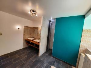 ein Badezimmer mit einem Waschbecken und einer blauen Wand in der Unterkunft Maison de caractère / Petit Versailles Normand in Valognes