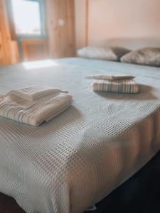 uma cama branca com duas toalhas dobráveis em Söğüt Tinyhouse & Glamping em Marmaris