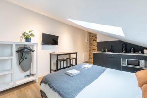 a bedroom with a large bed and a kitchen at LIK APPARTS - La Courrouze Rennes in Rennes +28 photos