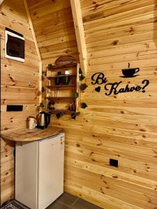 a kitchen with a refrigerator in a wooden wall at SHATOBUNGALOV in Çamlıhemşin