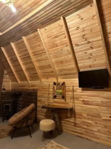 a room with a wooden wall with a flat screen tv at SHATOBUNGALOV in Çamlıhemşin