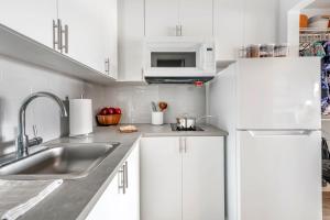 a white kitchen with a sink and a microwave at InTown Suites Extended Stay Select Orlando FL - Lee Rd in Orlando