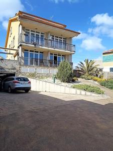 a house with a car parked in front of it at Apartamento delante de la playa. in Ribeira