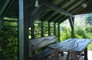 a wooden bench and a table in a pergola at Morgi na Łebkach in Łebki