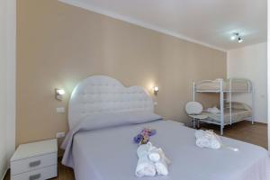 una camera da letto con un letto bianco e scarpe sopra di CalaBisso a Calasetta