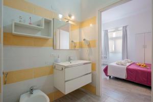 un bagno con lavandino, servizi igienici e un letto di CalaBisso a Calasetta