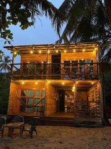 a wooden house with lights on top of it at HOSTAL Estrellas del tayrona playa in Santa Marta