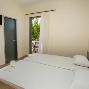 sypialnia z białym łóżkiem i oknem w obiekcie Villa Elista w mieście Astris