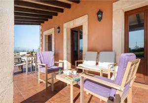 patio con sedie viola, tavolo e finestre di Villa Vernisa 454 a Can Picafort