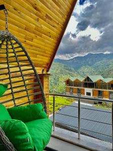 a swing on a porch with a view of a mountain at SHATOBUNGALOV in Çamlıhemşin