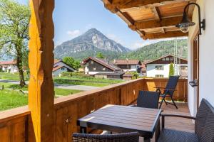 einen Balkon mit einem Tisch, Stühlen und einem Berg in der Unterkunft Ferienwohnung Johanni in Farchant