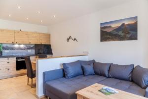 a living room with a couch and a kitchen at Ferienwohnung Vrenal in Farchant