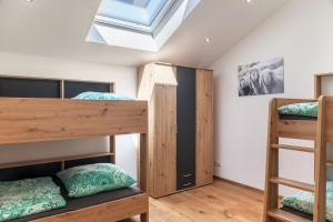 a room with three bunk beds and a skylight at Ferienwohnung Vrenal in Farchant