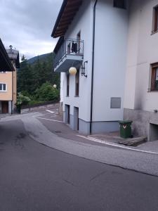 uma rua vazia ao lado de um edifício branco com varanda em Casa Domenica em Mezzana