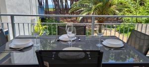 een tafel met glazen en borden op een balkon bij Miramar Serveis - Reus Mediterrani Primera Línea de Mar in Cambrils