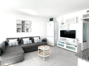 salon z kanapą, telewizorem i stołem w obiekcie Payen Corralejo by Best Holidays Fuerteventura w Corralejo