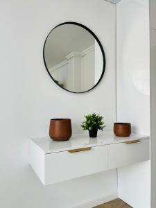 a mirror on a white shelf in a bathroom at Dendro Apartment in Cluj-Napoca