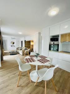 a kitchen and living room with a table and chairs at Dendro Apartment in Cluj-Napoca