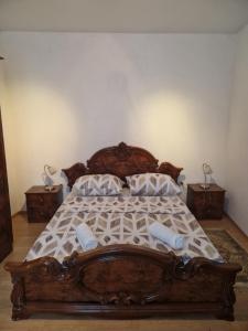 1 dormitorio con 1 cama de madera y 2 mesitas de noche en Guest House Sunshine, en Mostar