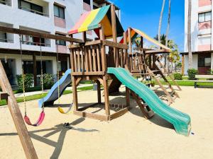 a playground with a slide and a swing set at Palmilla 301,depa 5 min de playa in Mazatlán
