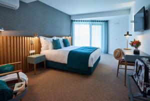 a hotel room with a large bed and a couch at Rochavau Hotel in Portimão