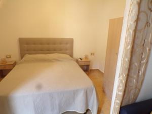 a bedroom with a white bed and two tables at LA CASA DEL LIMONE - Via Umberto 477 in Roccalumera