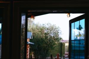 une fenêtre avec vue sur un arbre à l'extérieur dans l'établissement منتجع مزدان, à Unayzah