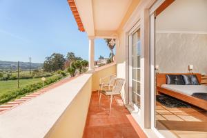 een slaapkamer met een balkon met een bed en uitzicht bij Casa da Encosta in Nazaré