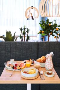 uma mesa de madeira com comida para o pequeno almoço em Rochavau Hotel em Portimão