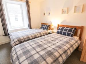 dwa łóżka siedzące obok siebie w sypialni w obiekcie 30 Union Street w mieście Kirkcudbright