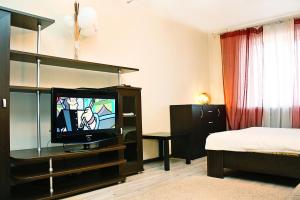 a room with a tv and a bed and a bedroom at Alliance Apartments na Gazetnom in Rostov on Don