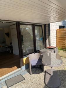 een patio met 2 tafels en stoelen op een balkon bij Rüngsdorf in Bonn