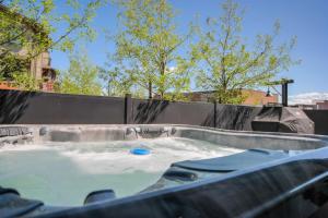 a hot tub filled with water with trees in the background at Stone Hollow 1884 townhouse in Park City