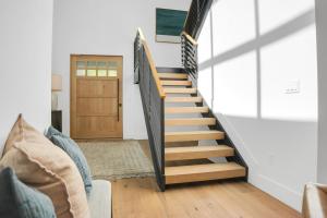 a staircase in a living room with a wooden stair case at Stone Hollow 1884 townhouse in Park City