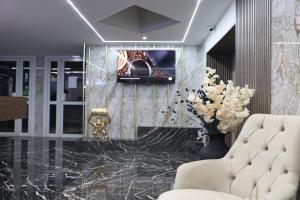 a lobby with a couch and a vase of flowers at Hôtel Restaurant Clément ADER in Muret